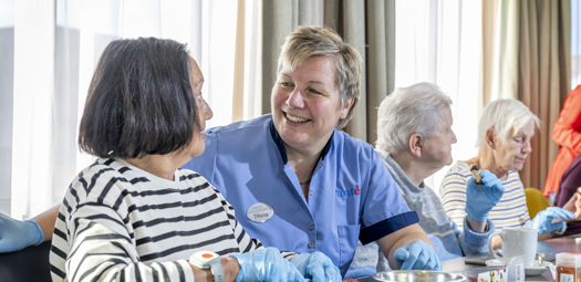 Medewerkster zorgcentra in gesprek met bewoner