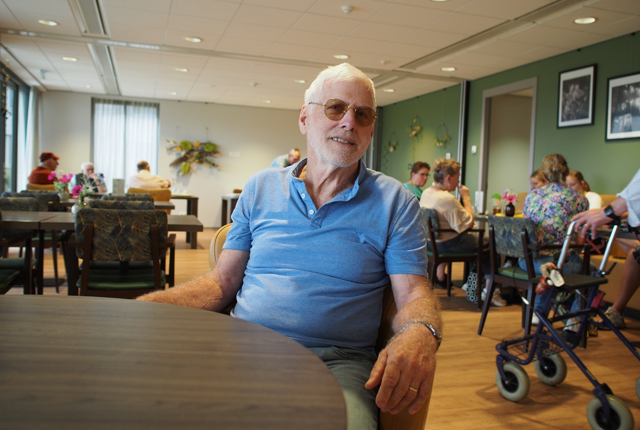 Mantelzorger zit in een zorgcentrum aan tafel
